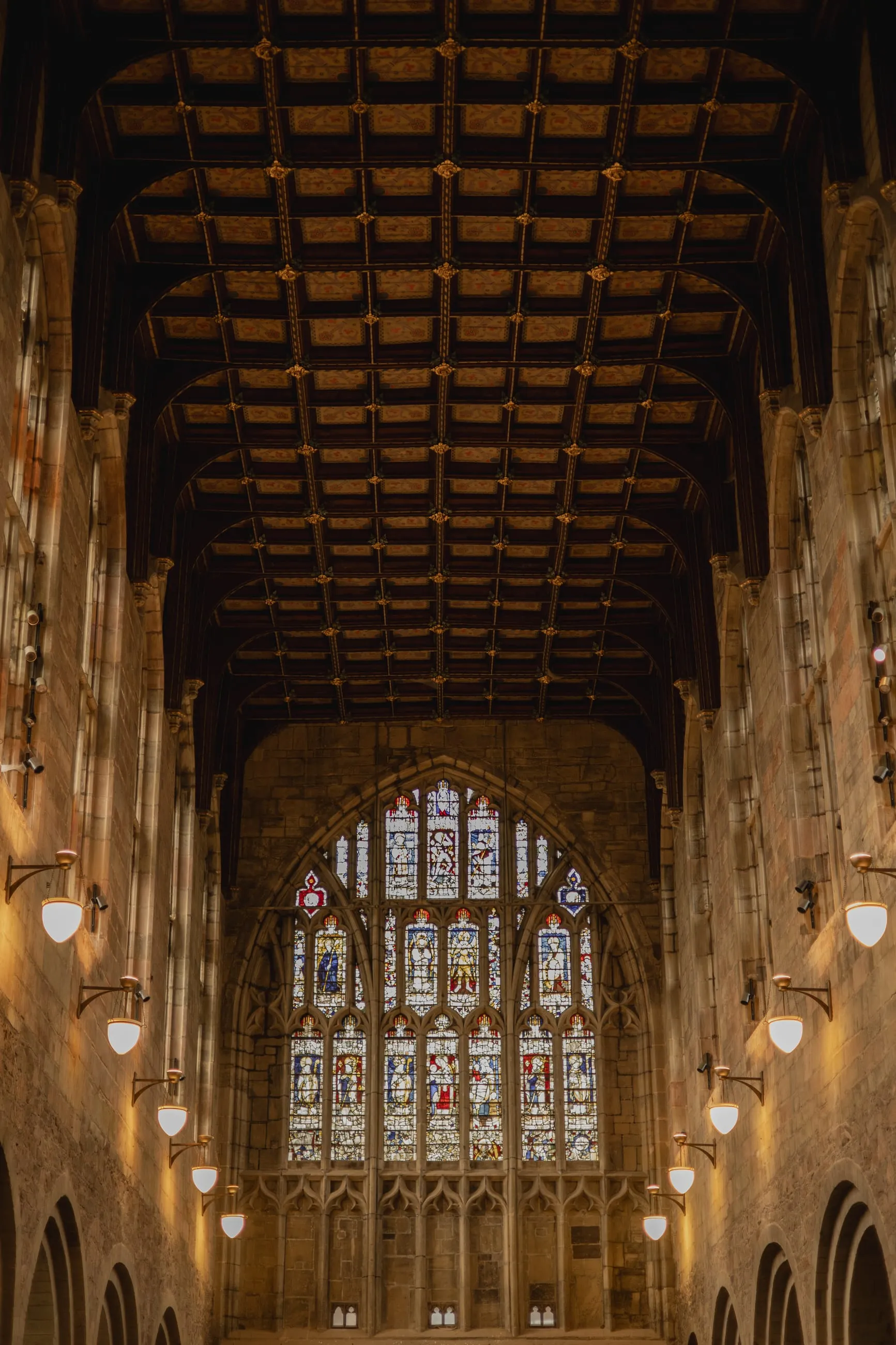 Church nave with timber ceiling and lit stained glass