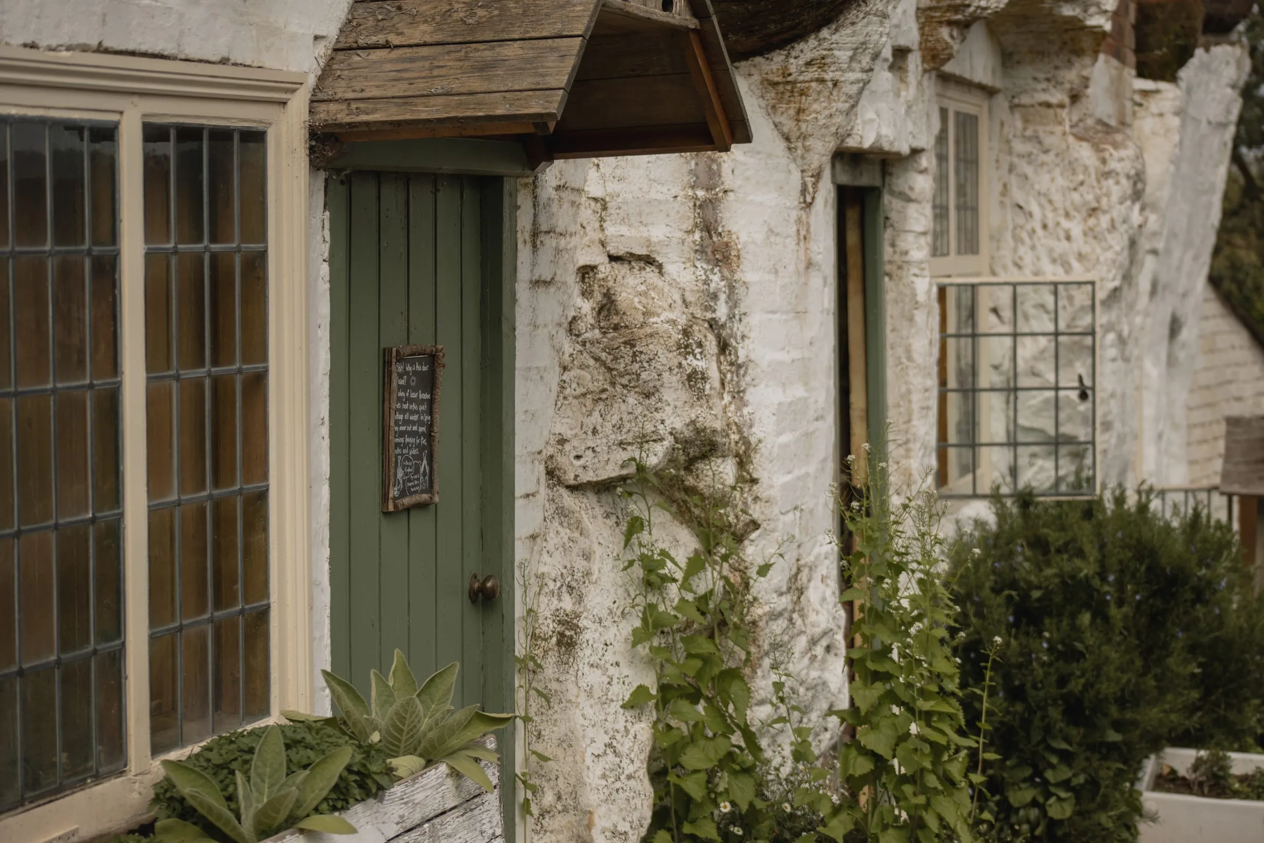 Whitewashed rock house front with green door