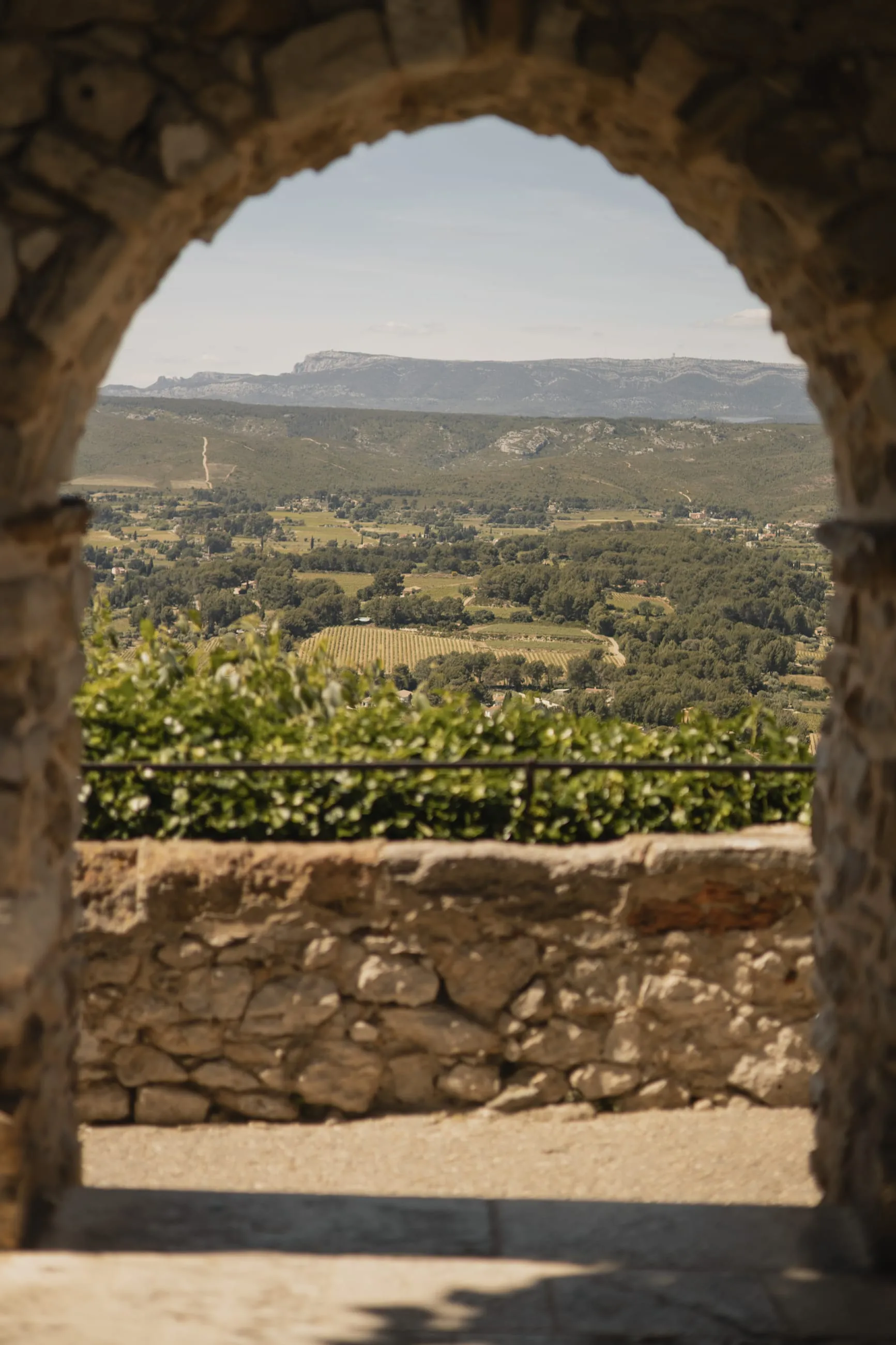 Stone arch framing a wide Provençal valley