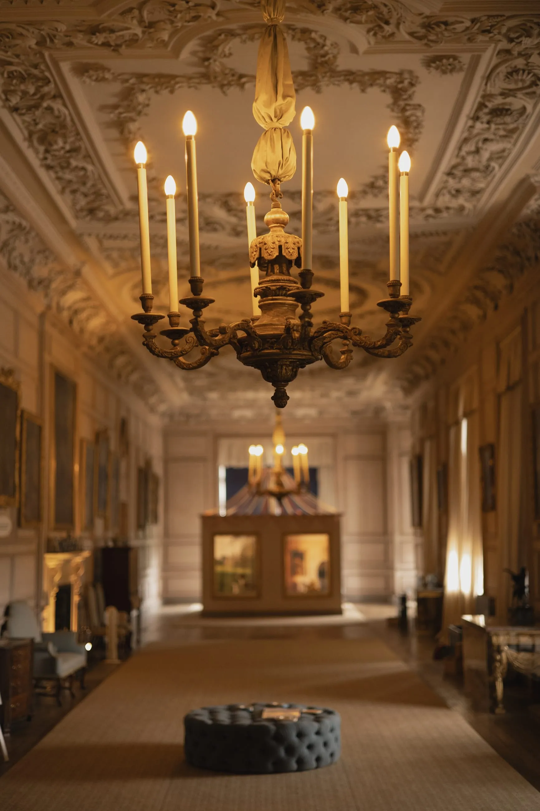 Long gallery with lit chandelier and plaster ceiling