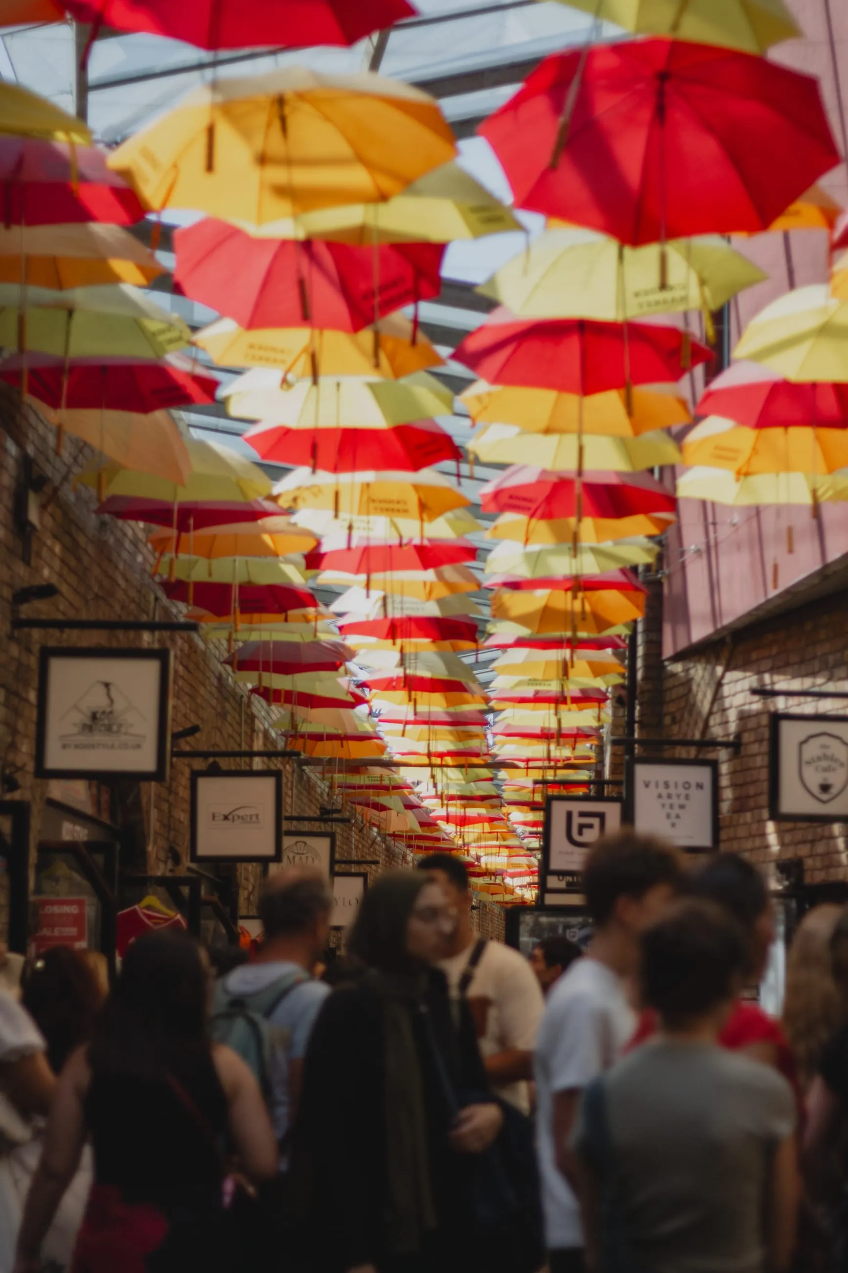 Red and yellow umbrellas strung over a crowded alley