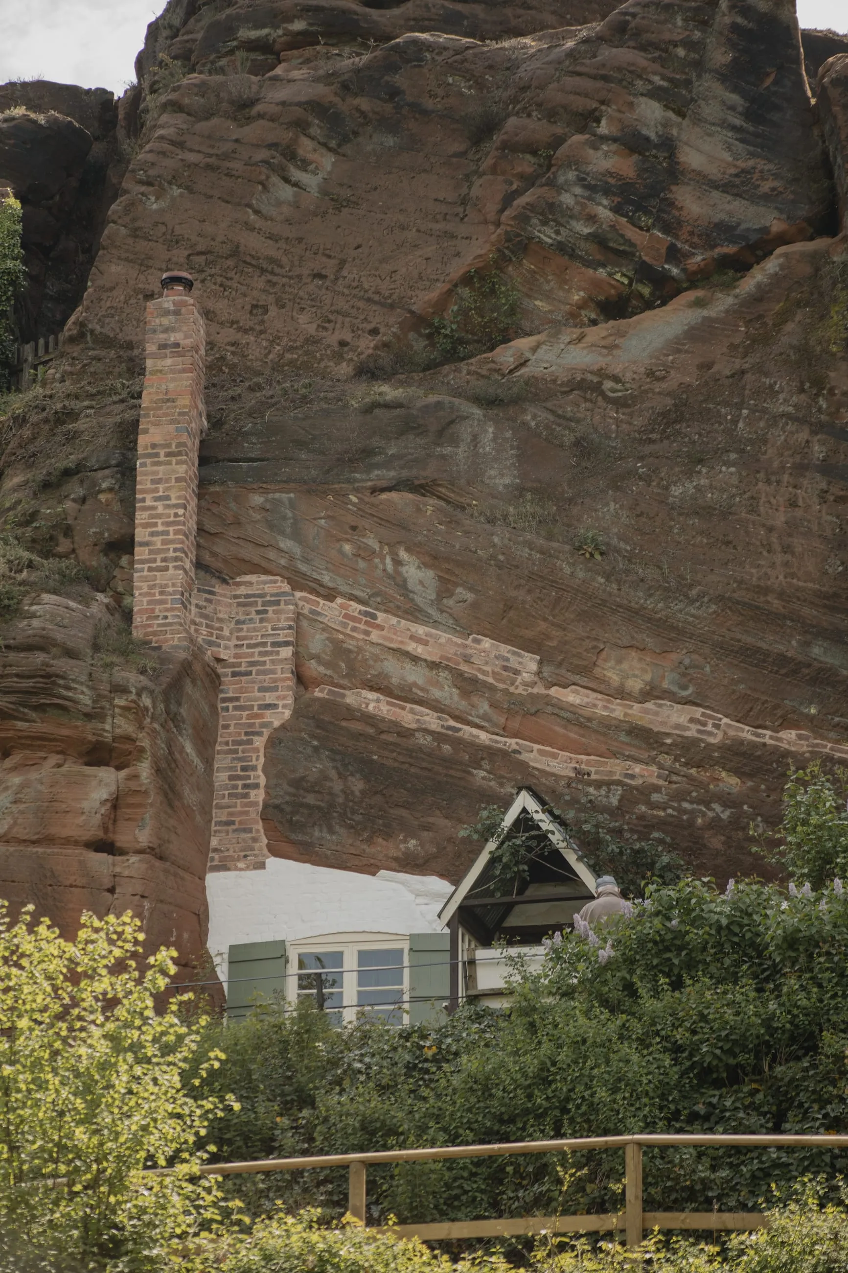 Falaise de grès rouge avec un cottage à son pied