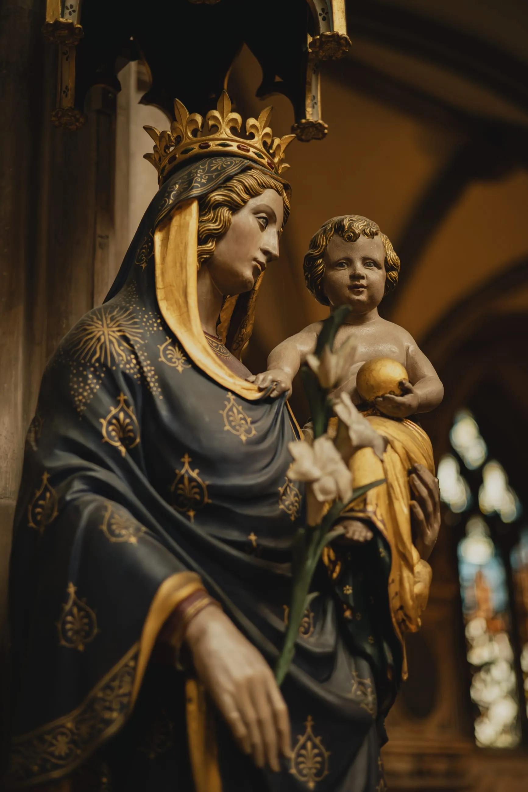 Crowned Madonna and child statue in warm light