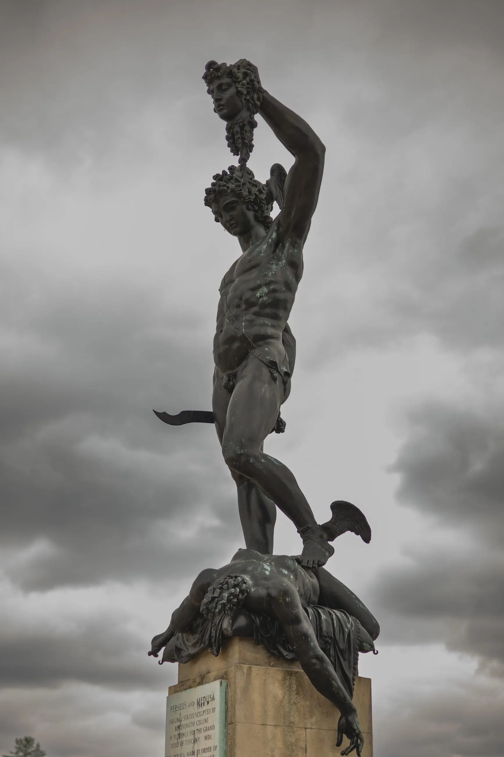 Bronze Perseus statue against heavy grey clouds