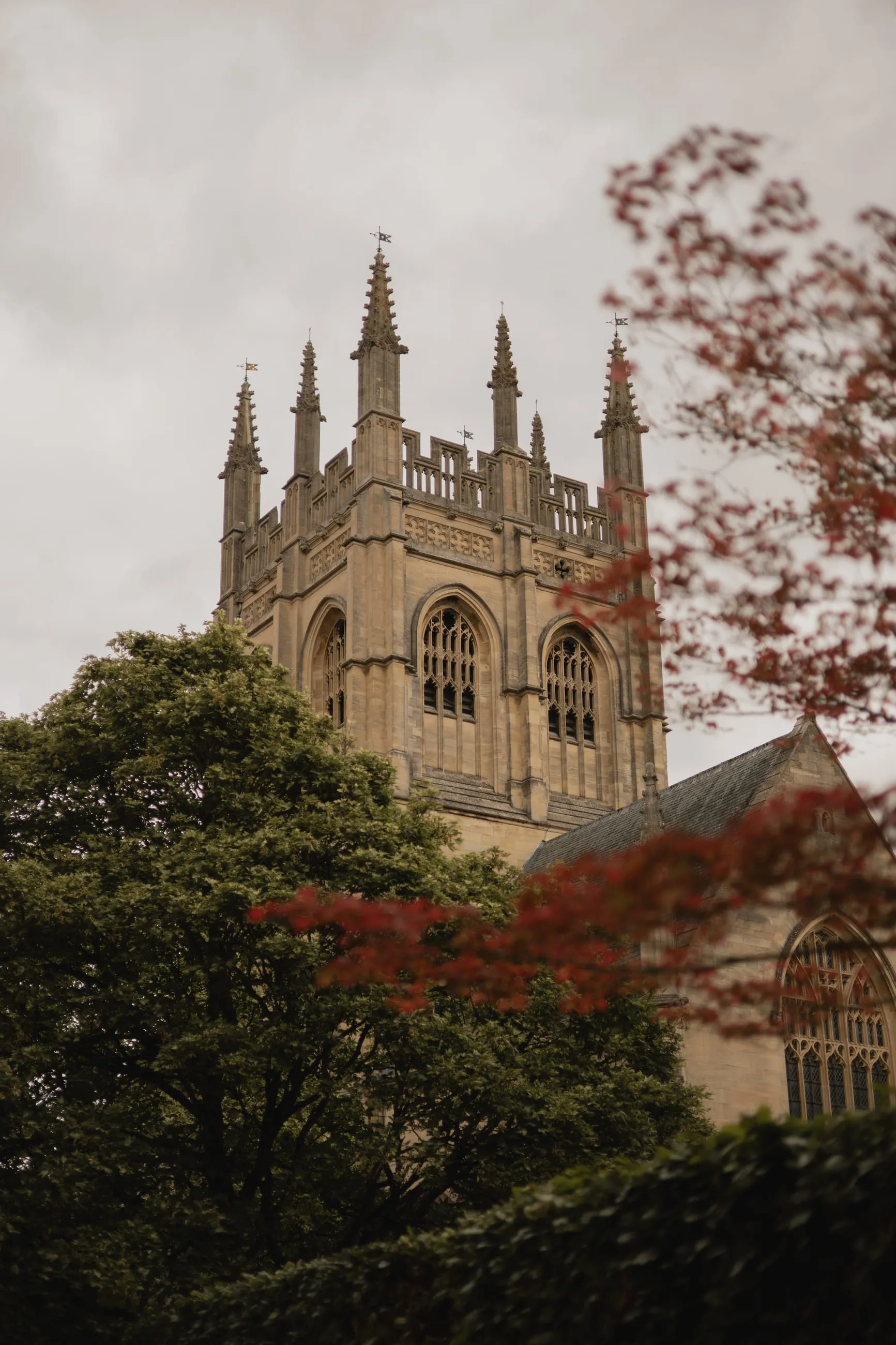 College tower behind trees with red foliage