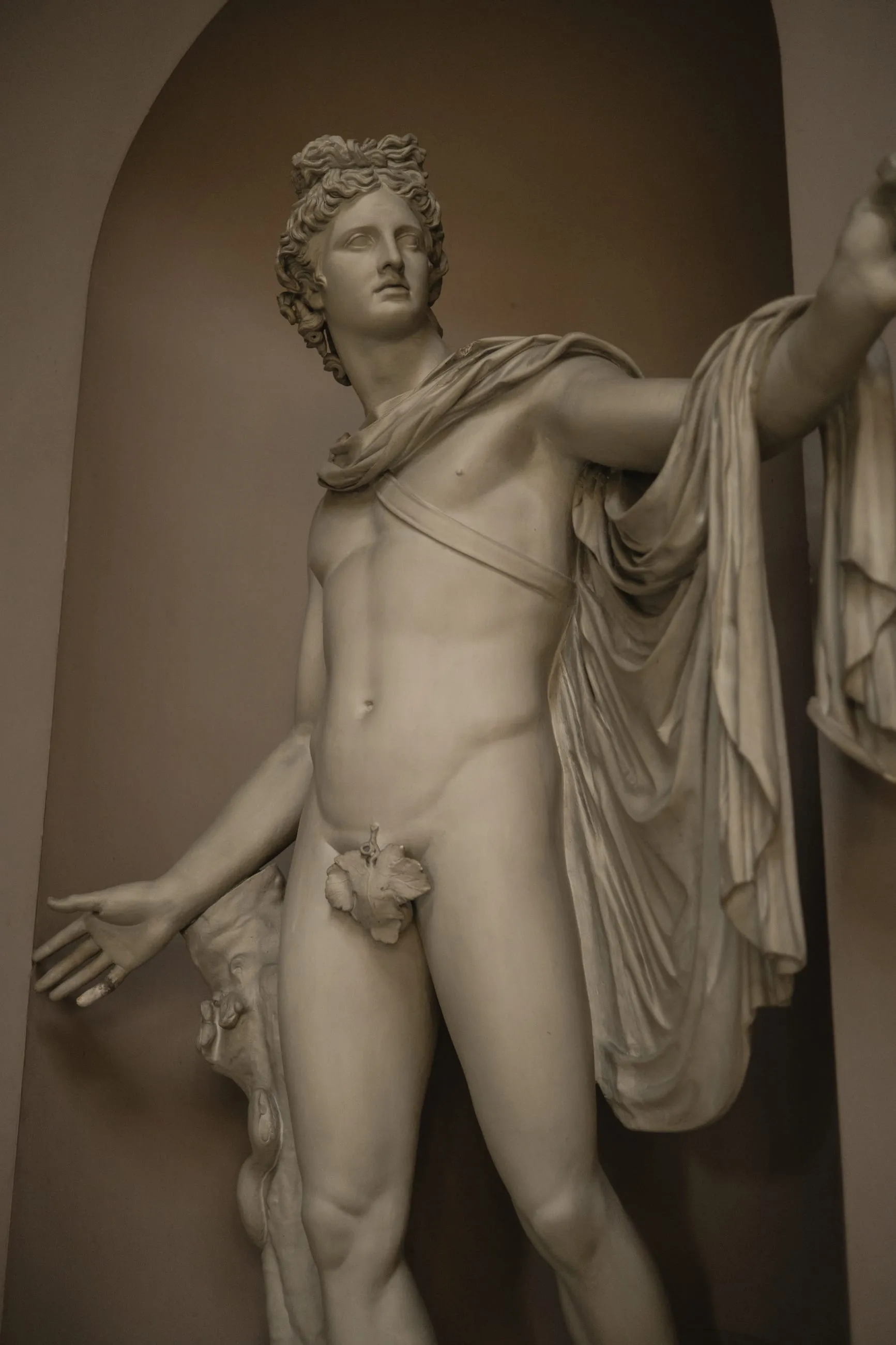 Marble statue of Apollo in a pale niche
