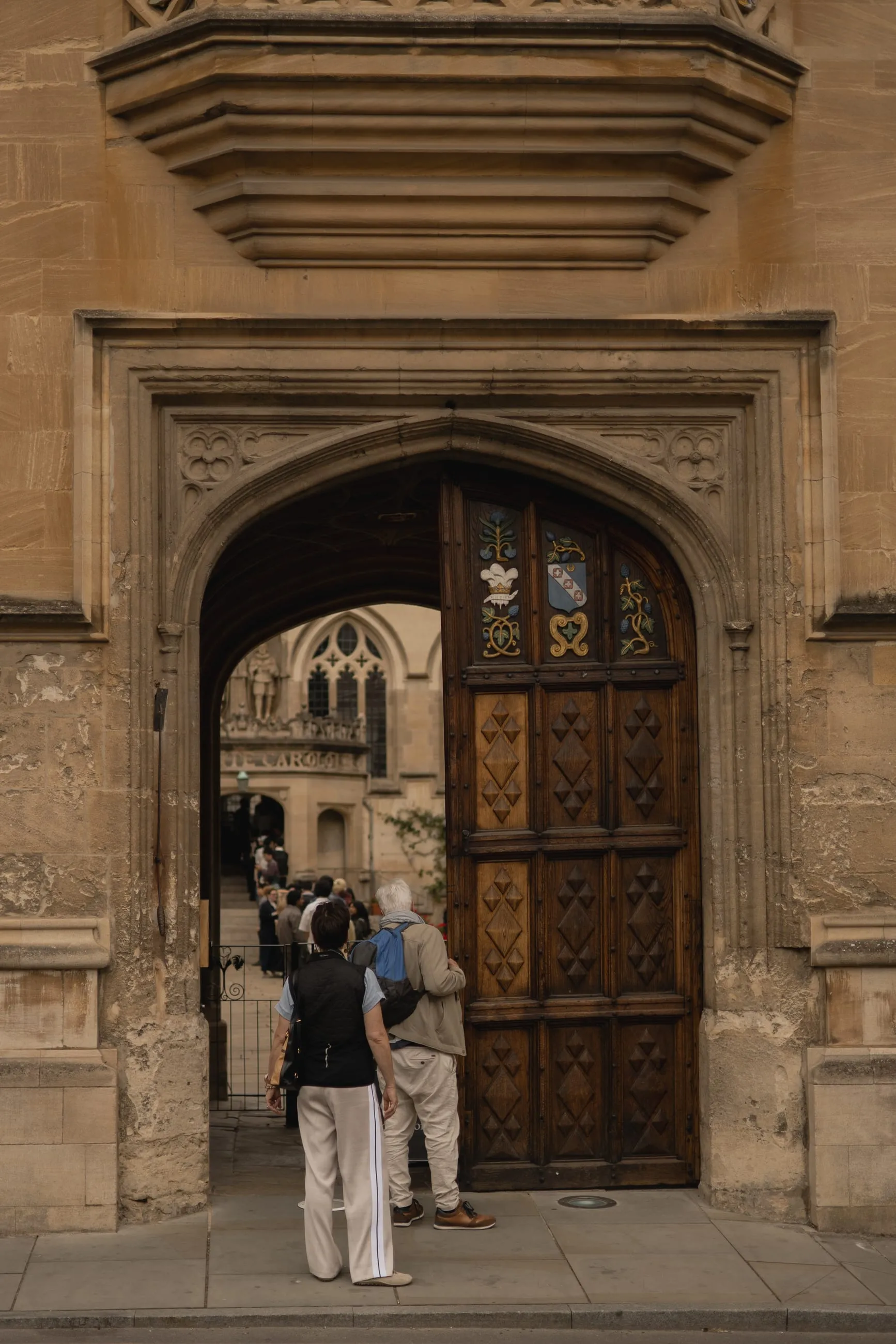 Visitors at a heavy carved wooden college door