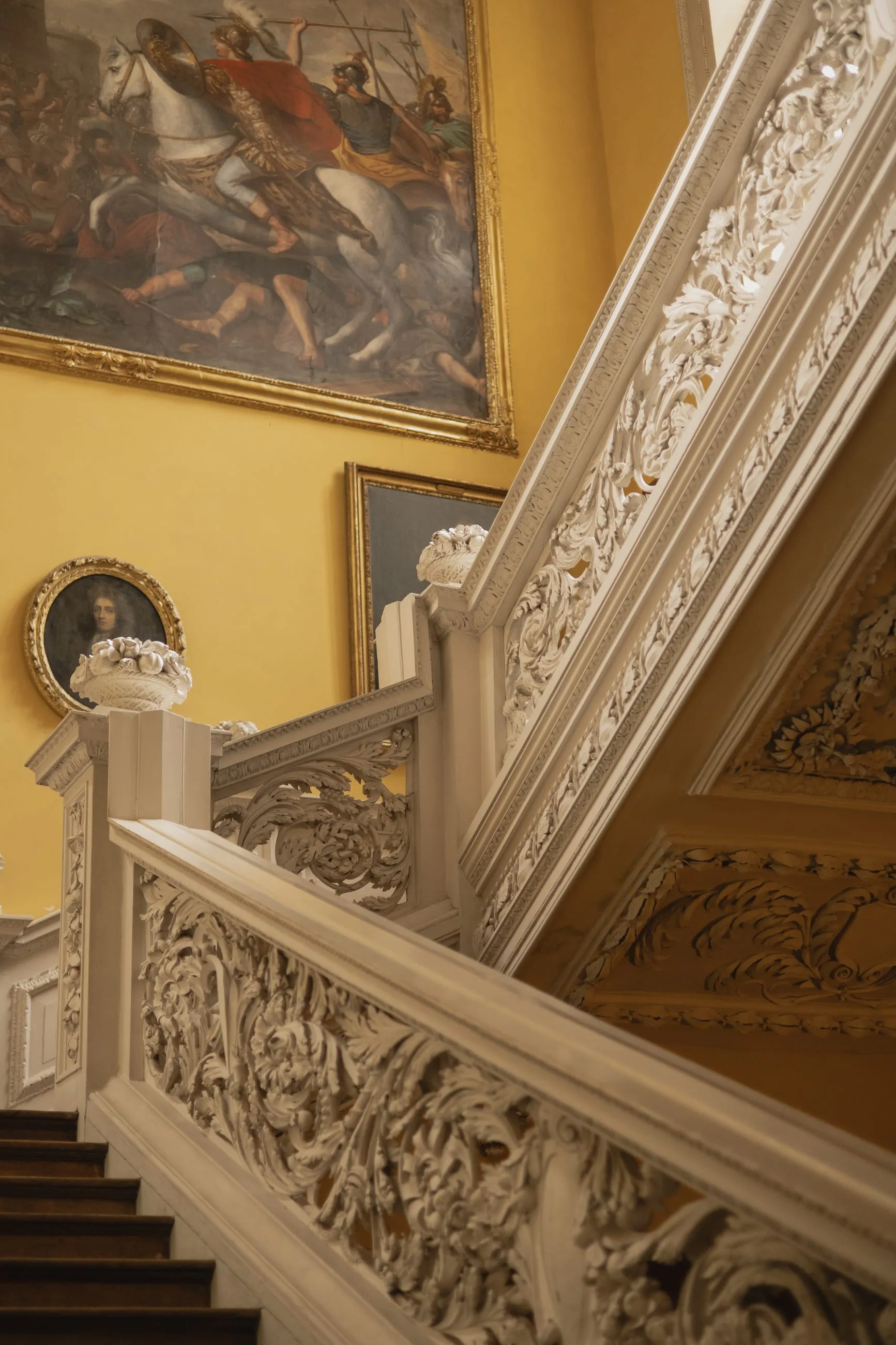 Carved white staircase balustrade against yellow walls