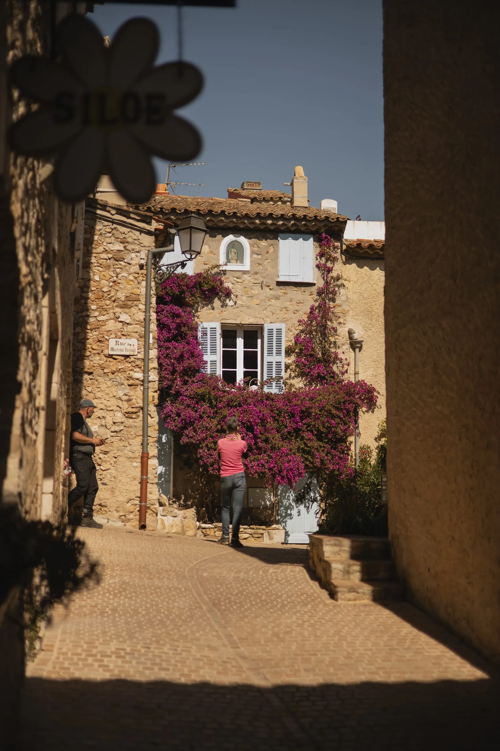 Bougainvillea over a stone house at an alley's end