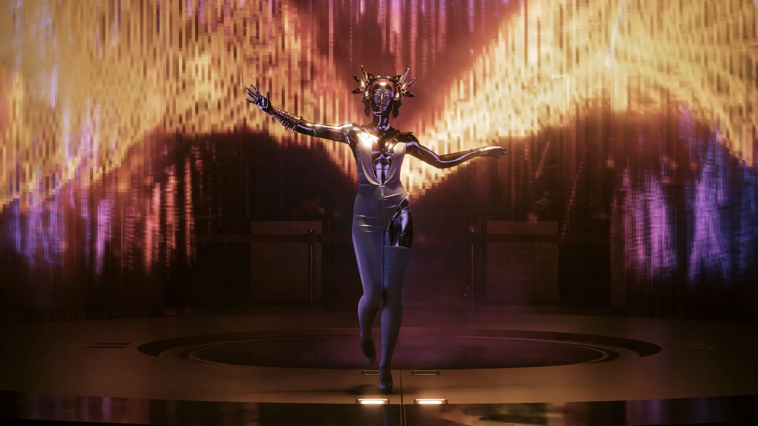 Performer with arms spread before a wall of golden light
