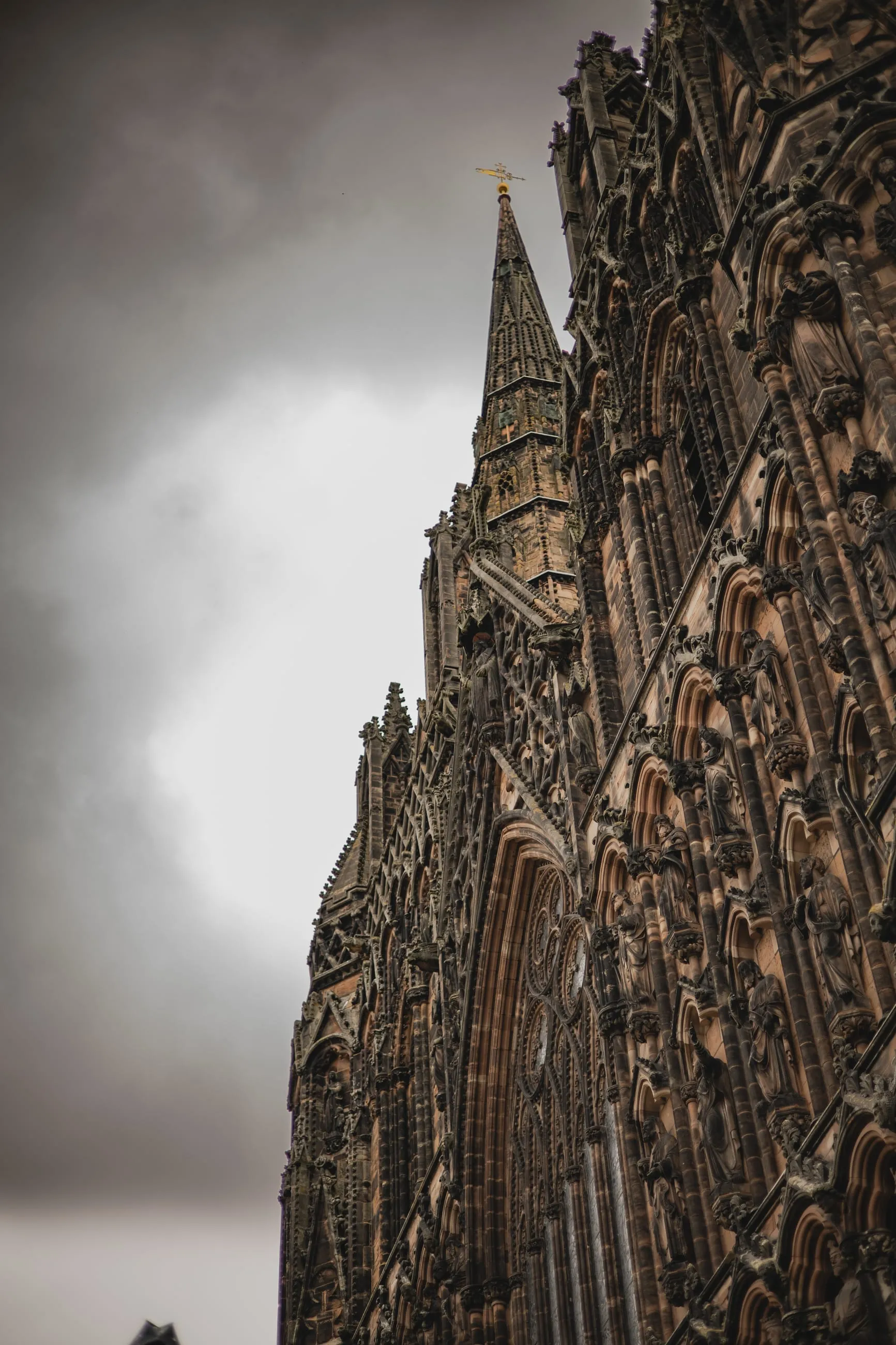 Carved west front looming against storm clouds