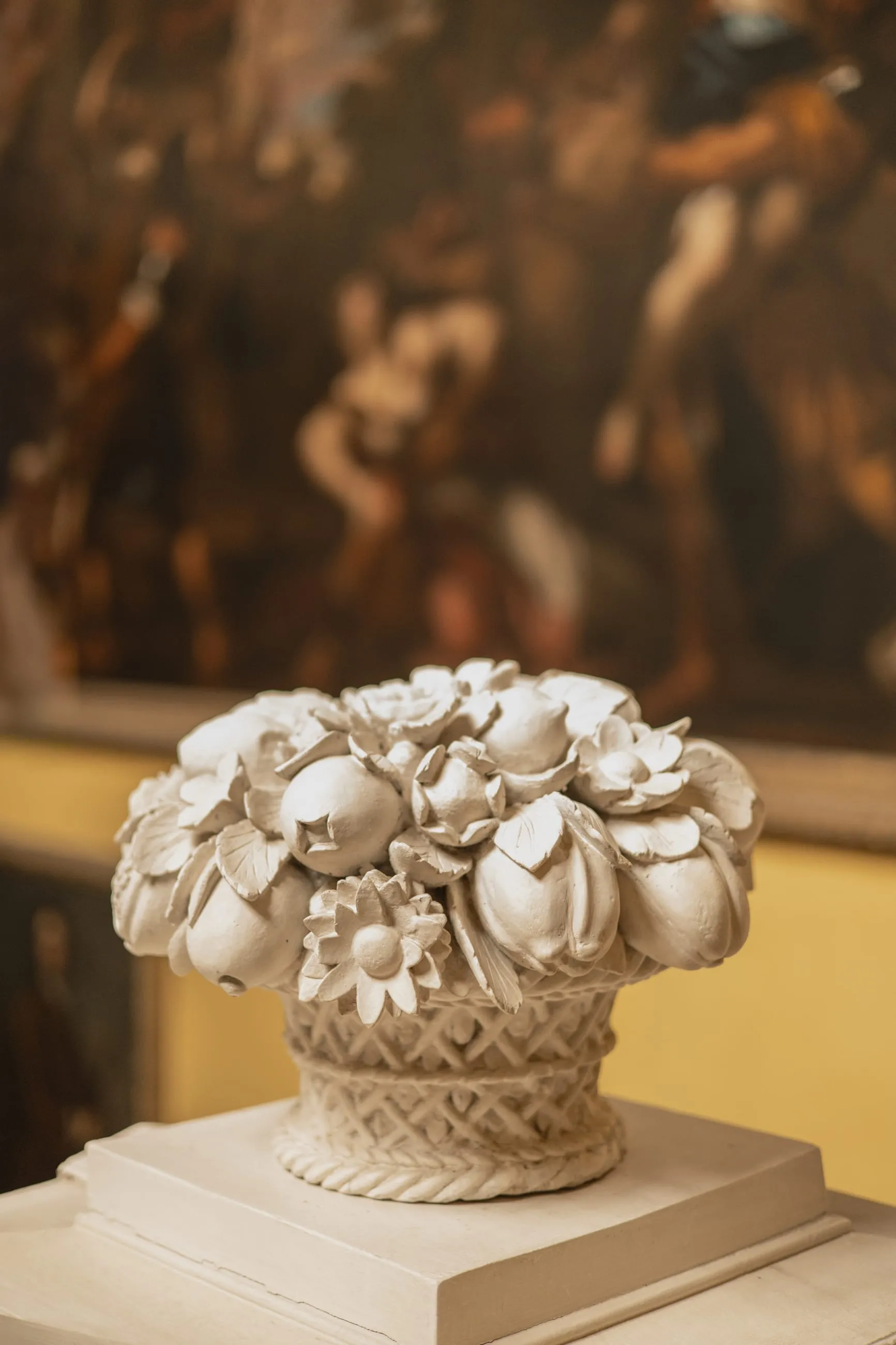 Marble basket of carved flowers before a painting