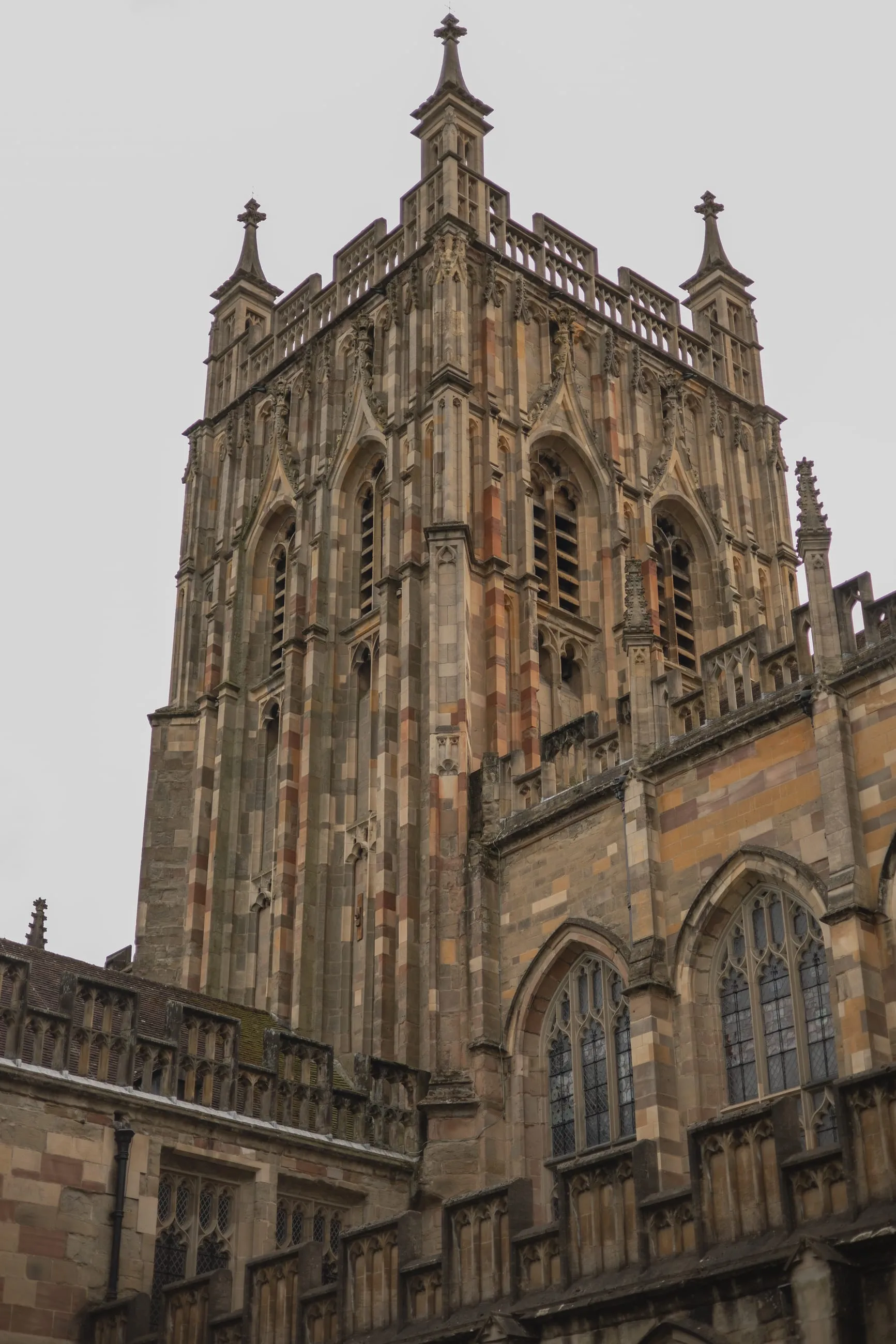 Malvern Priory tower against a white sky