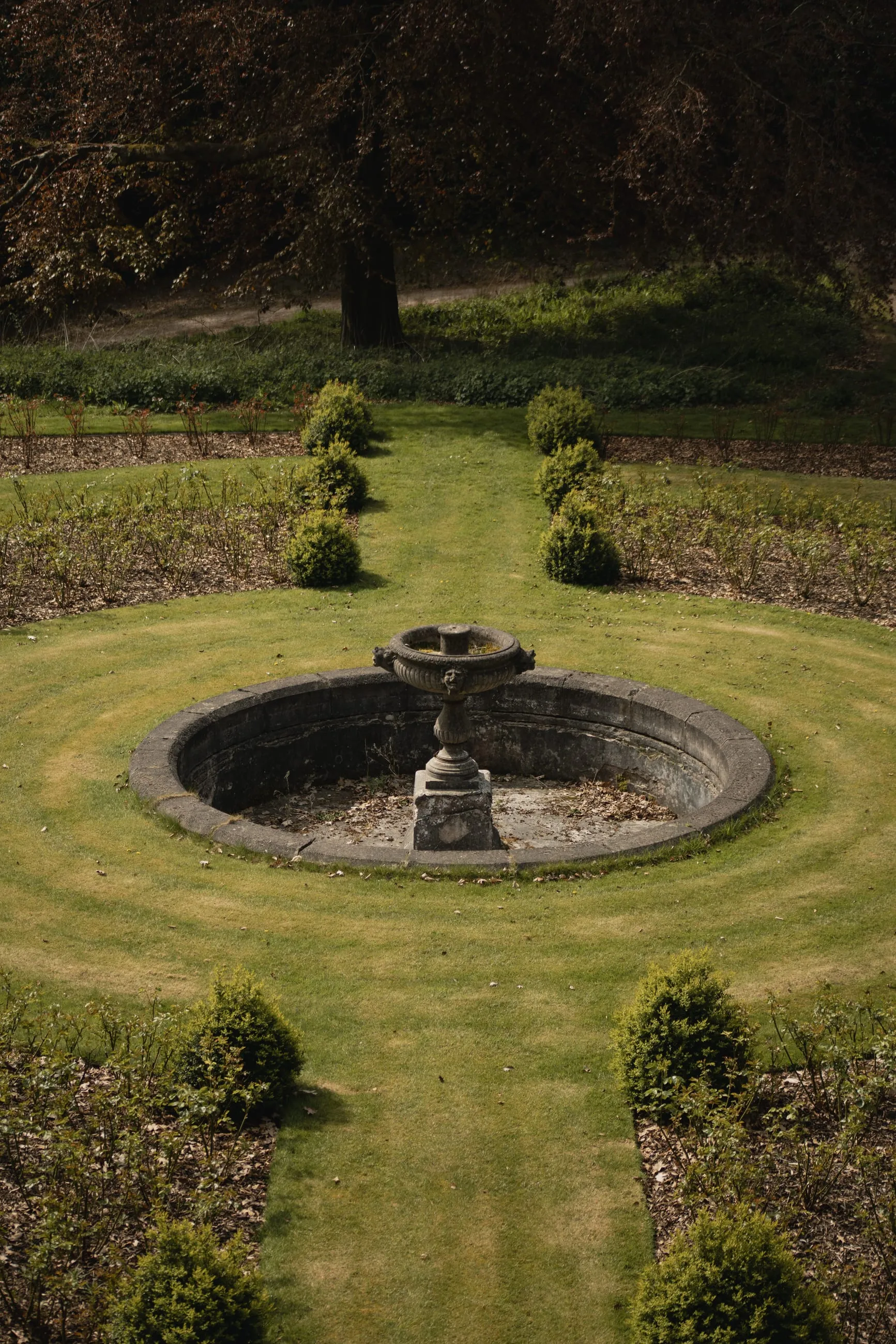 Circular stone fountain in a formal lawn
