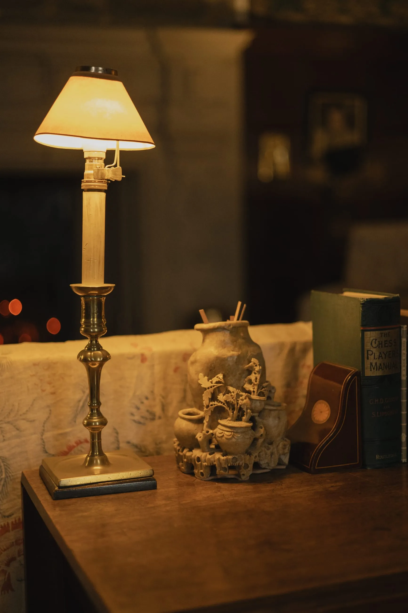 Glowing table lamp beside an ornament on a desk