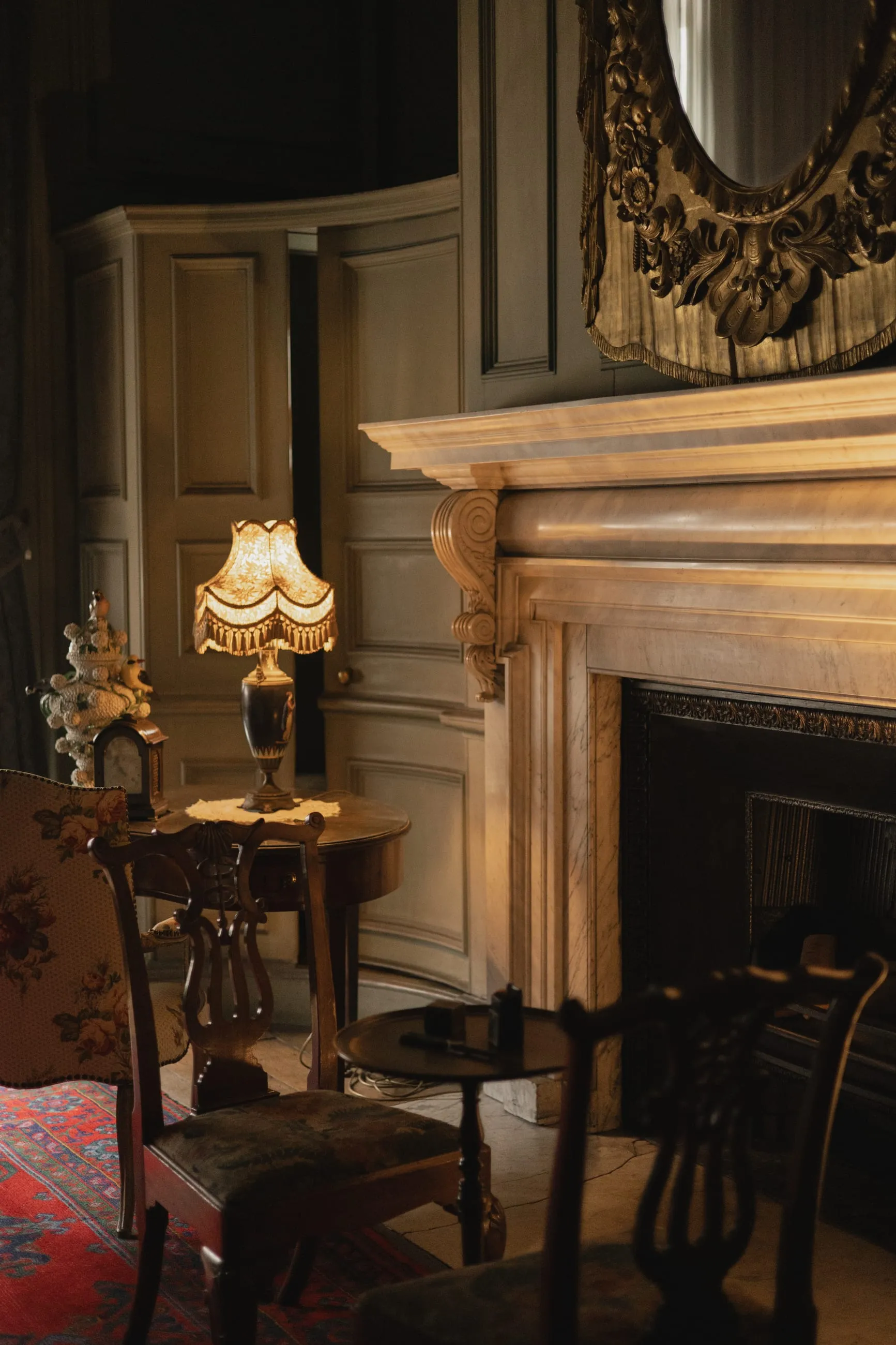 Fireplace and lamp in a dim panelled room
