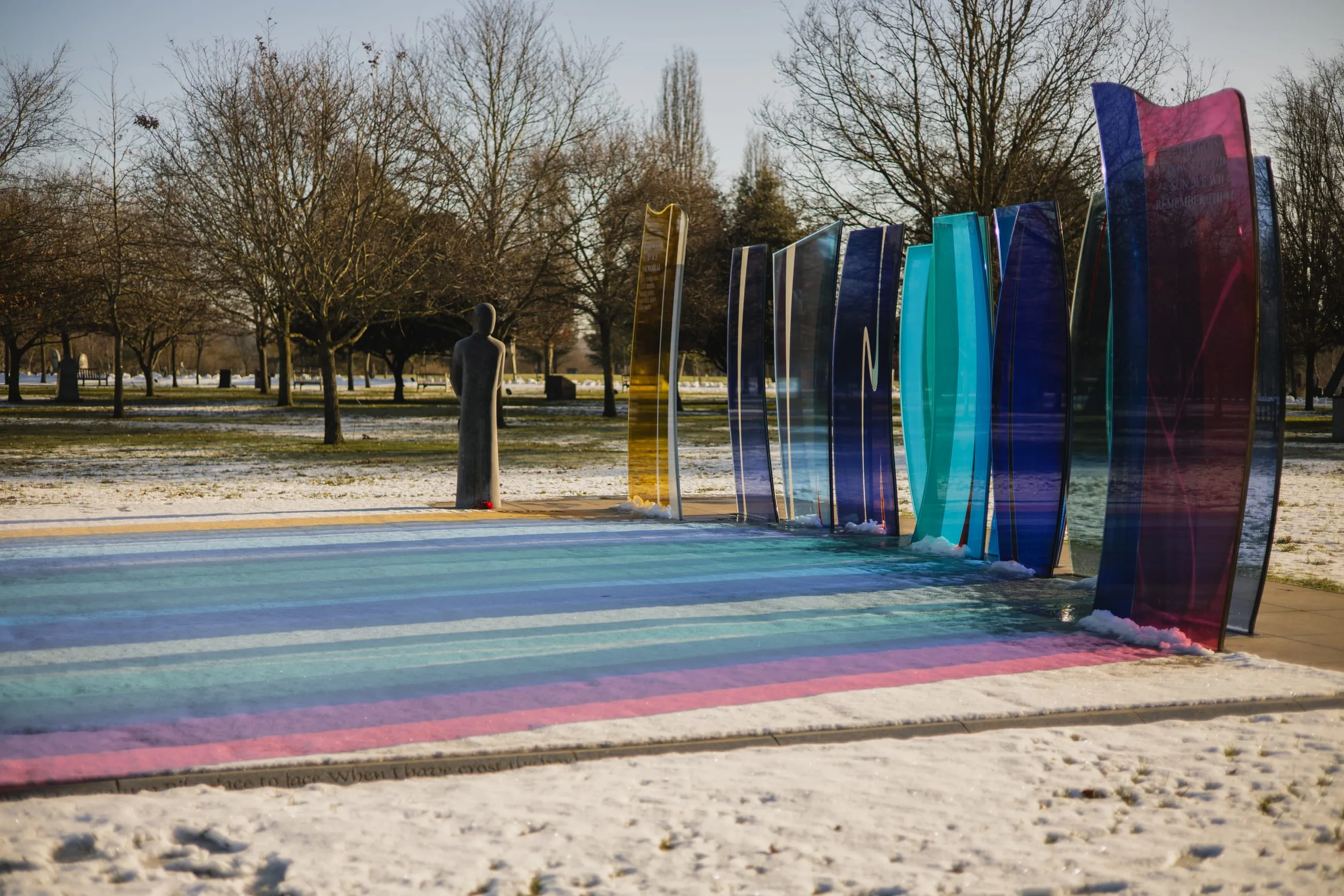 Rainbow glass panels casting colour on snow