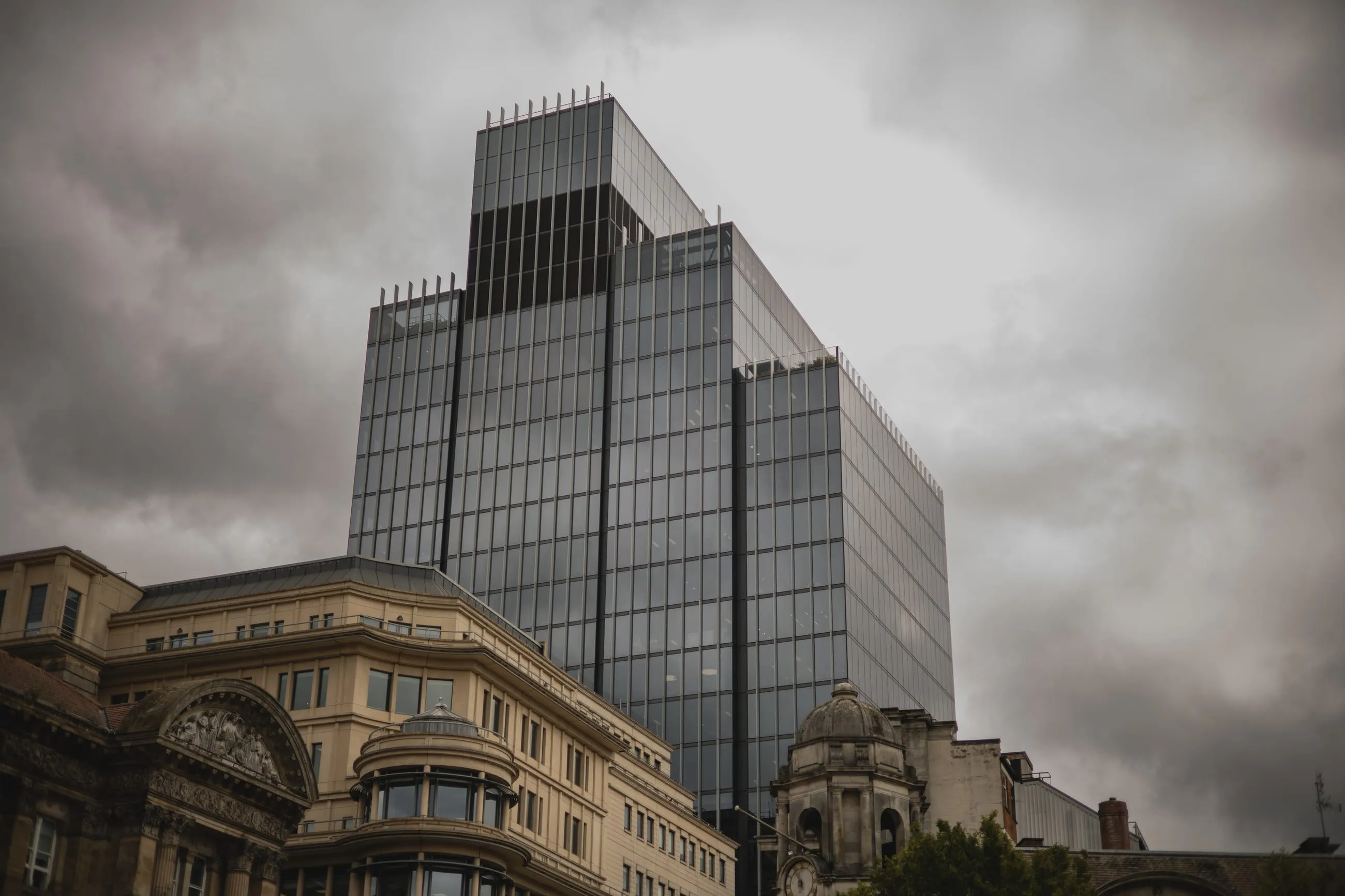 Glass office tower above Victorian rooftops