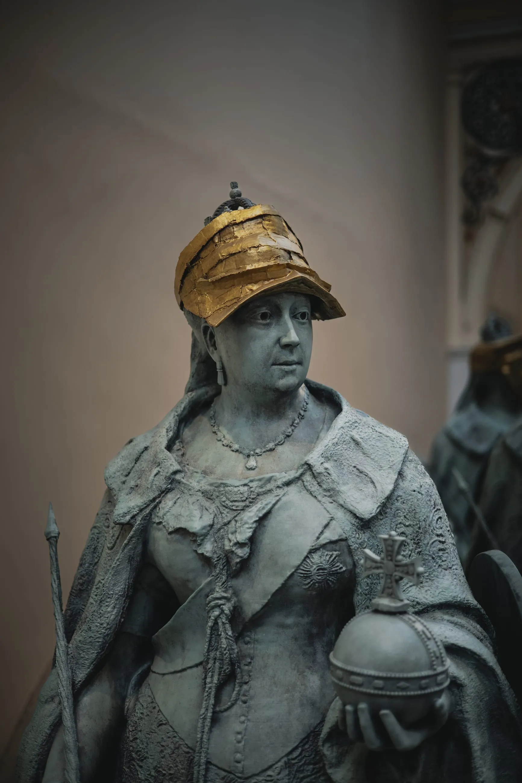 Weathered statue of a woman in a plumed helmet