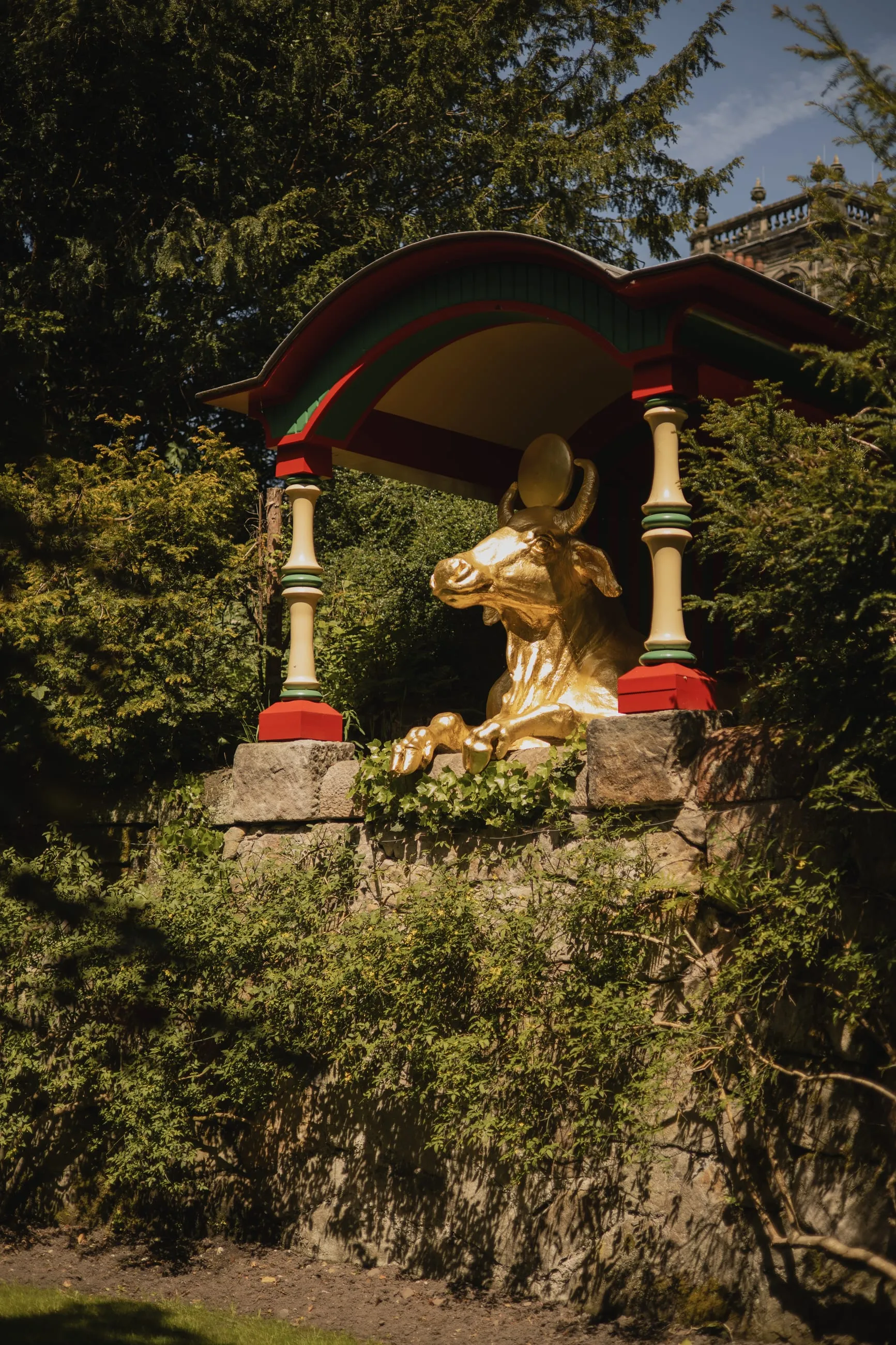 Gilded ox shrine half-hidden in foliage