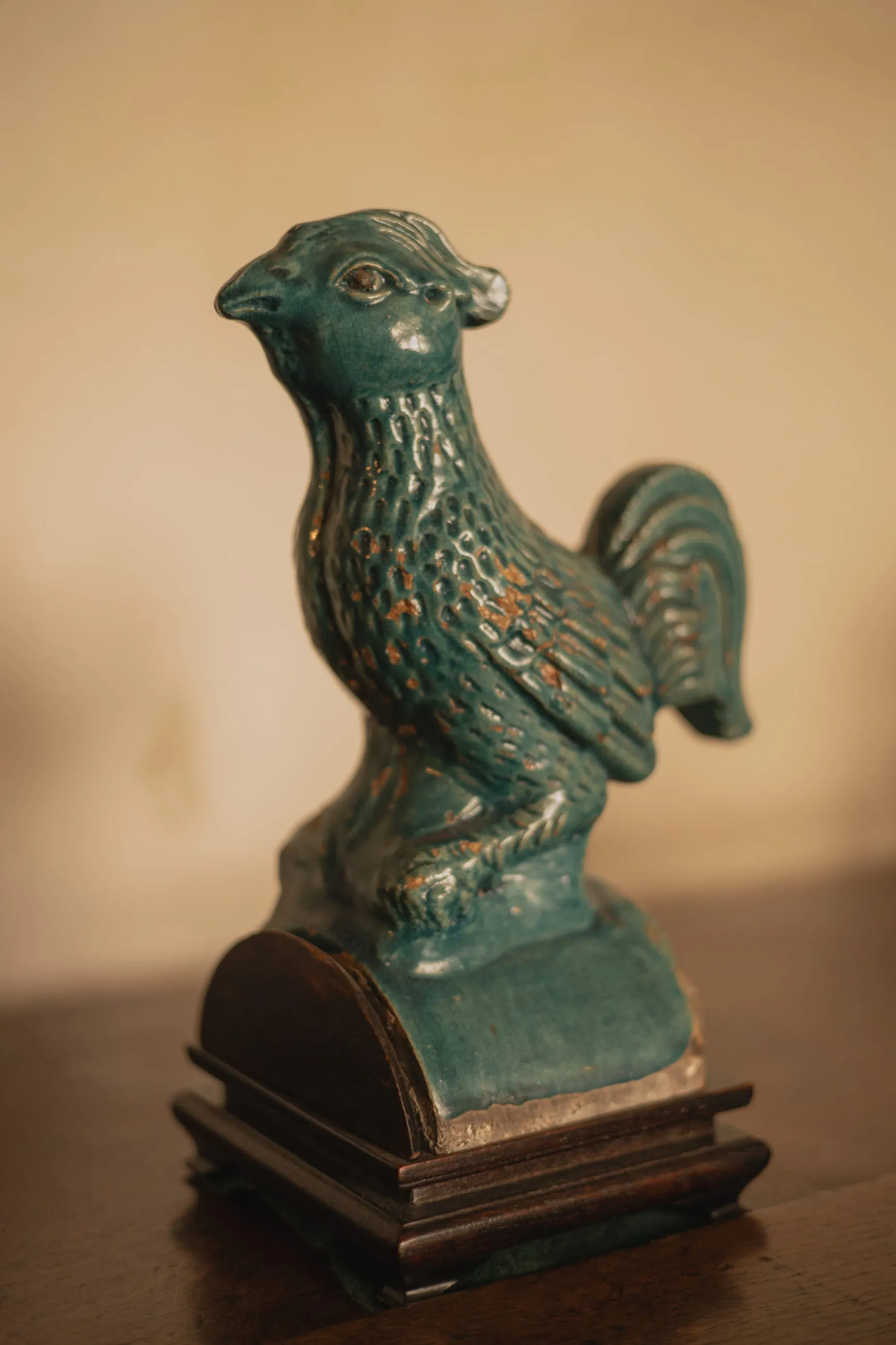Turquoise ceramic cockerel on a wooden table