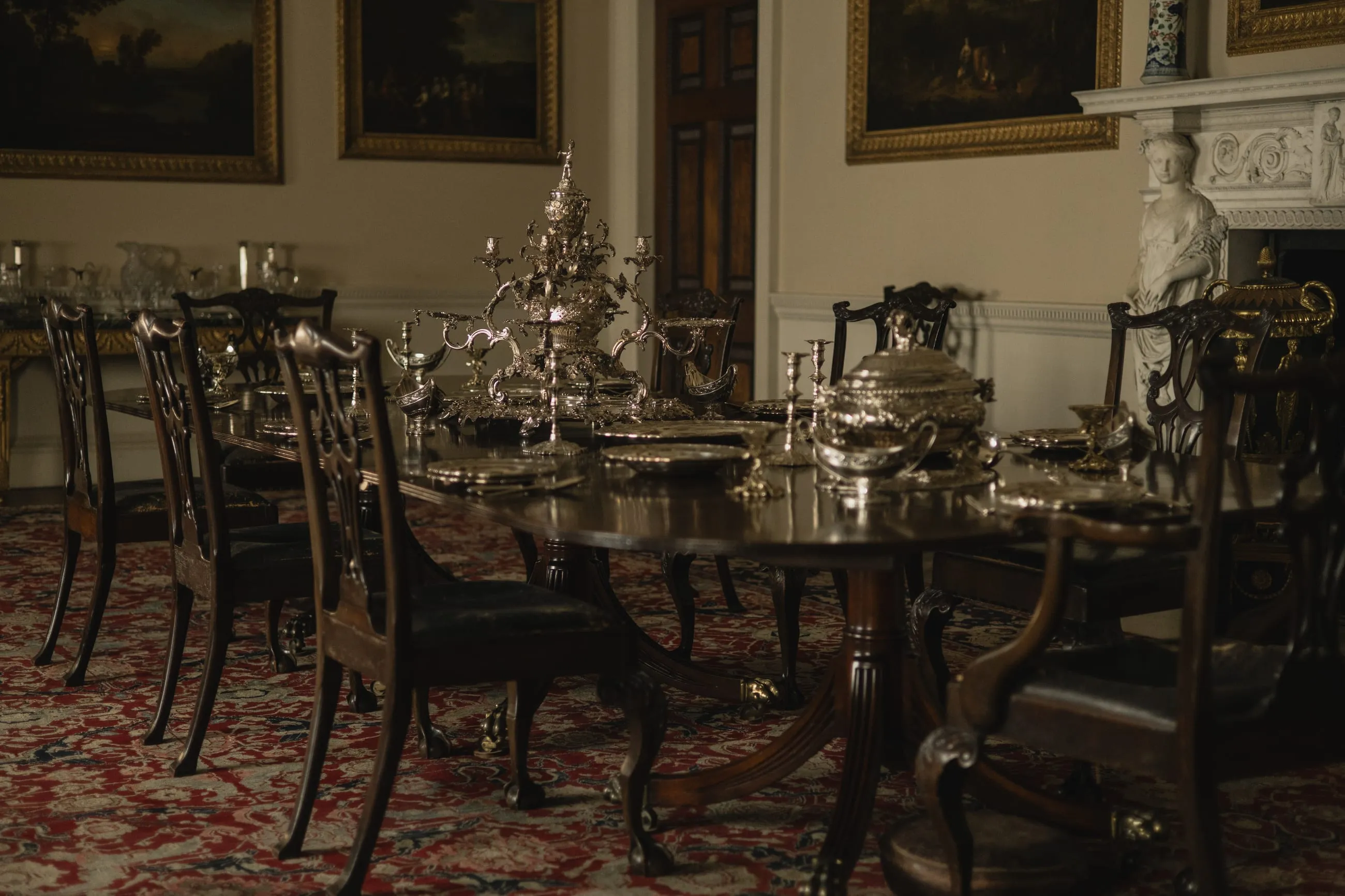 Dining room laid with silver beneath paintings