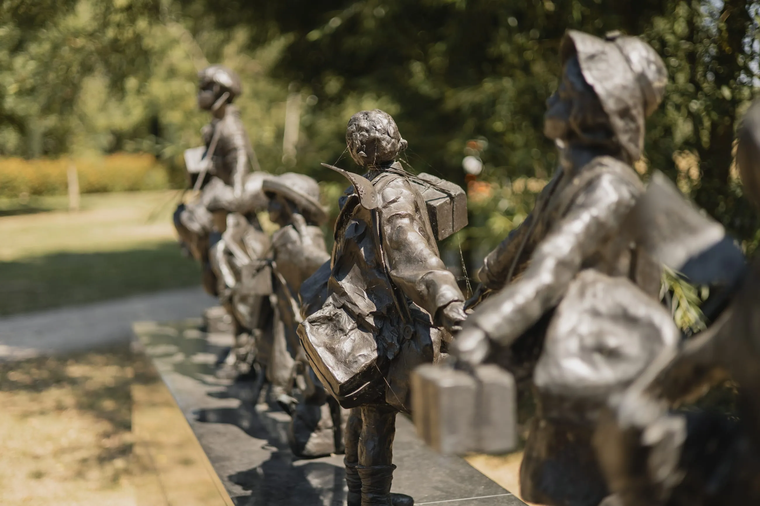 Row of small bronze evacuee children figures