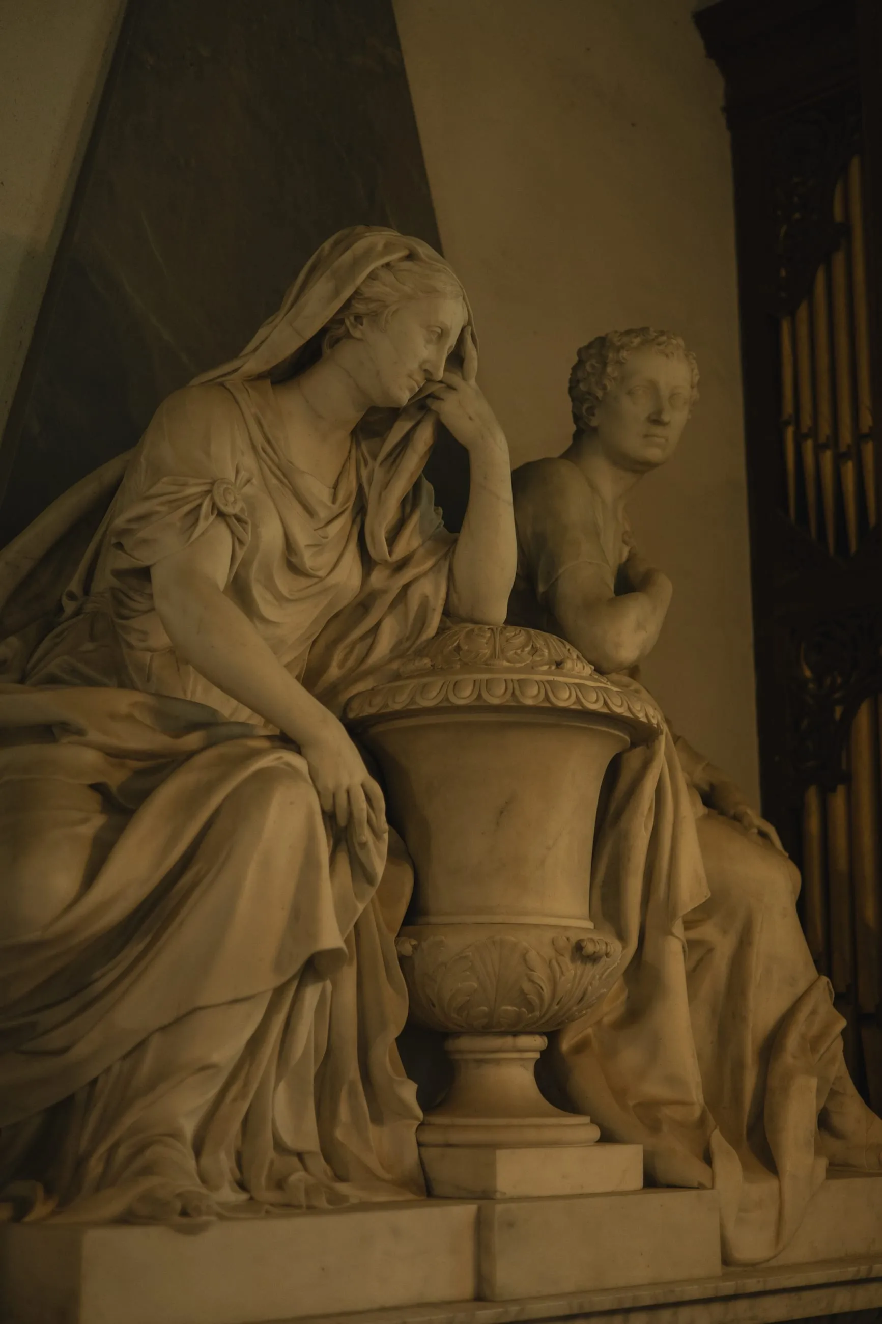 Marble mourning figure leaning on an urn