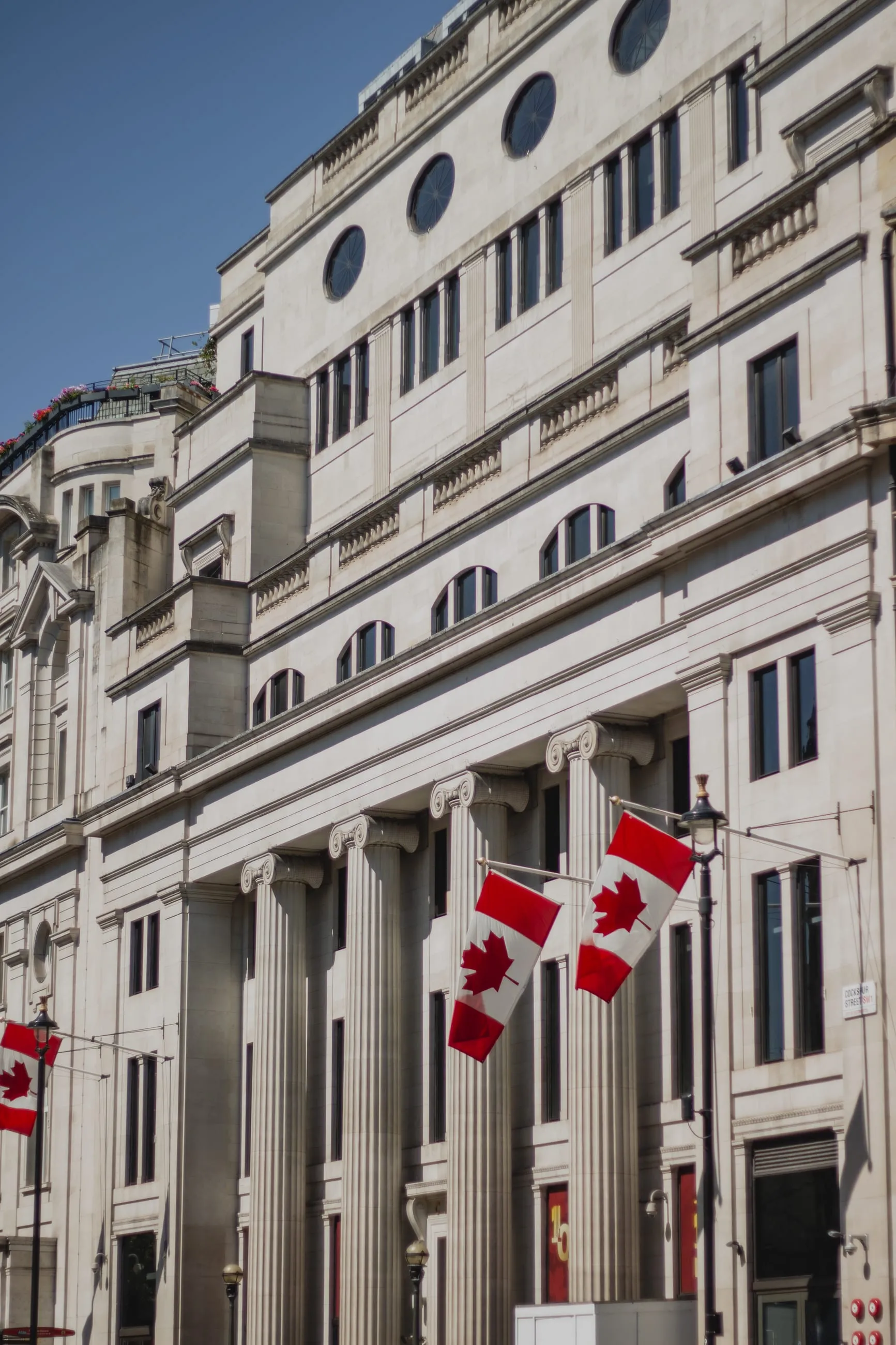 Canadian flags on a white colonnaded building