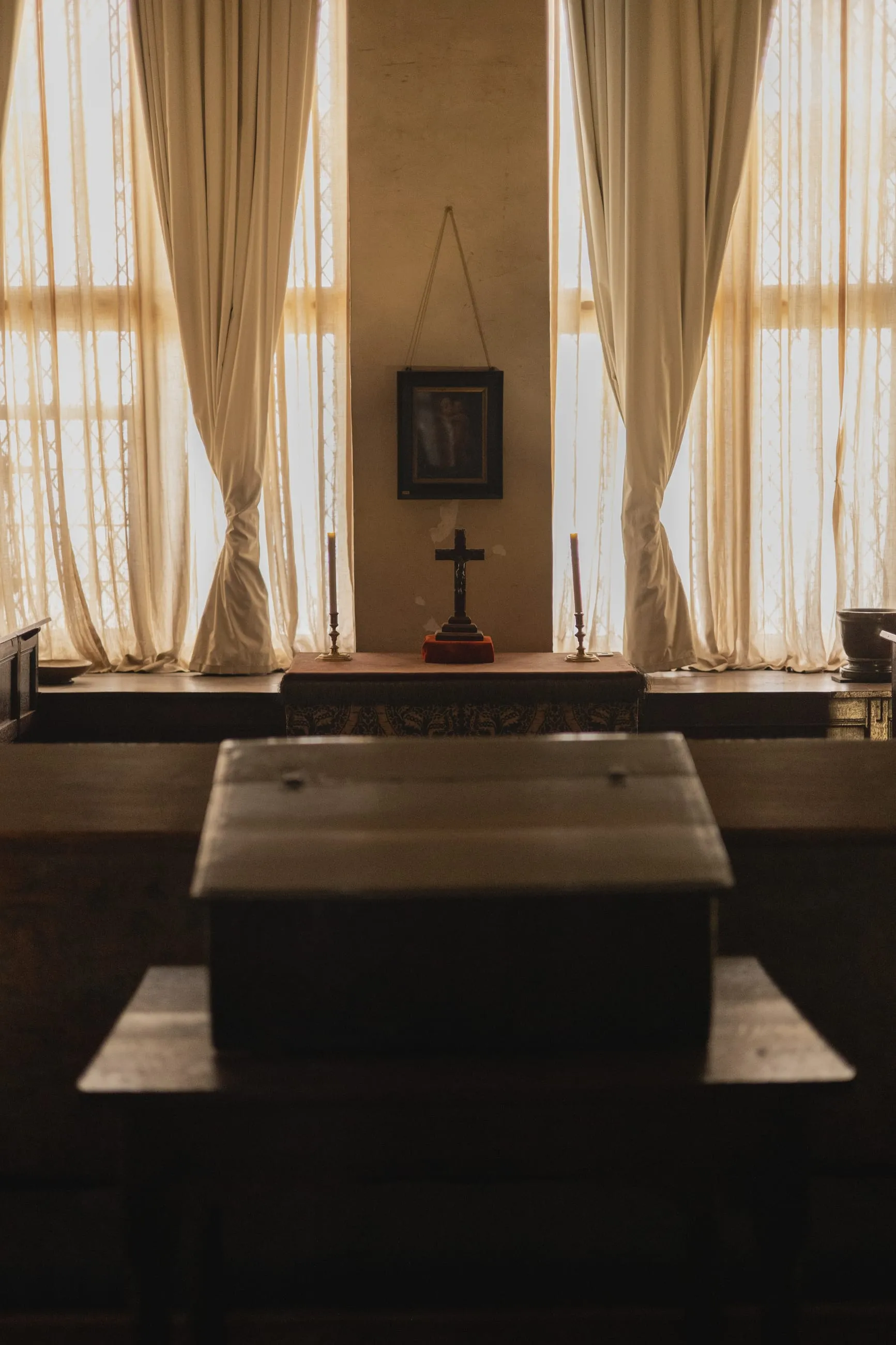 Chapel table before tall curtained windows