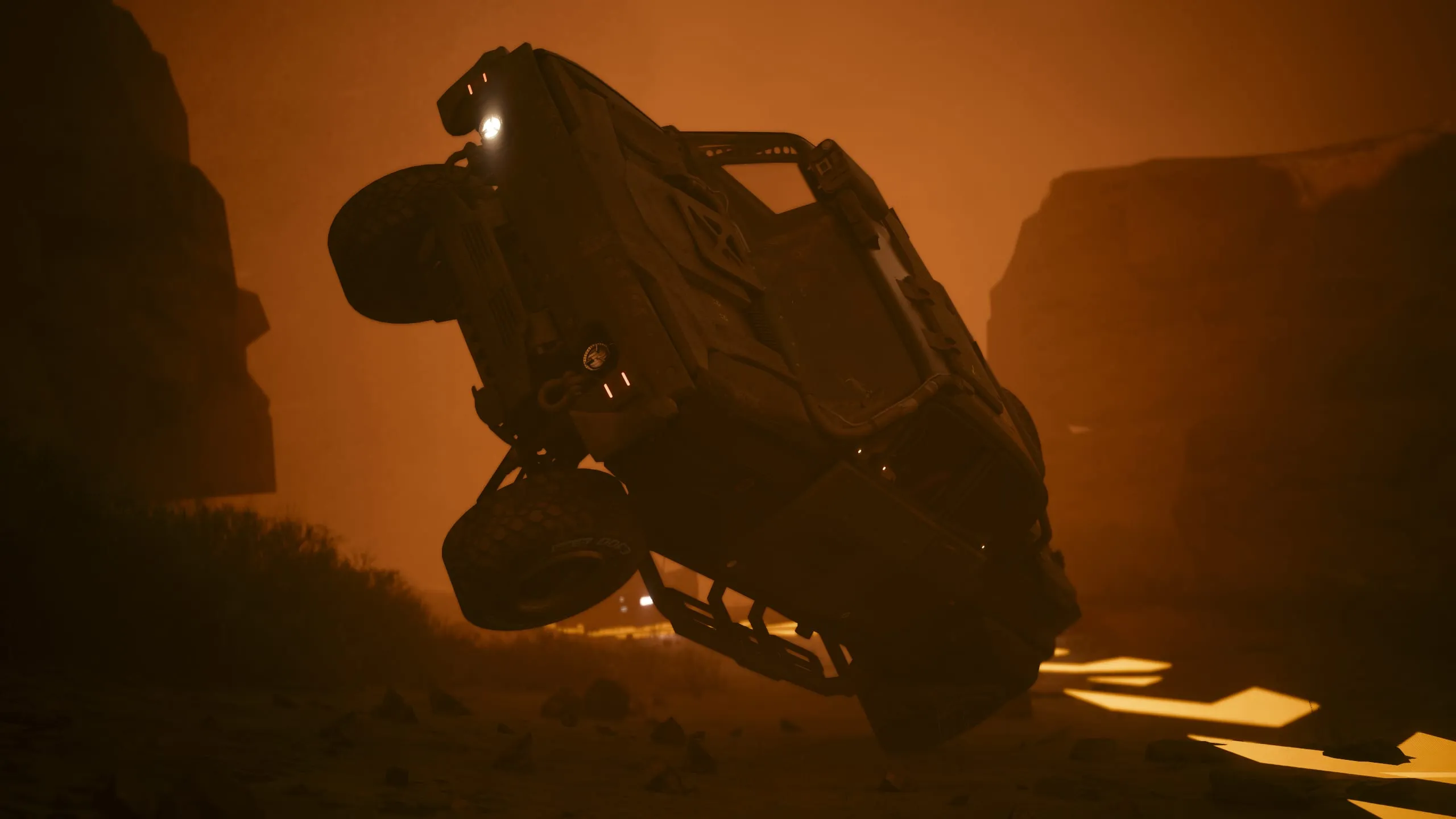 Car mid-roll silhouetted against orange canyon dust
